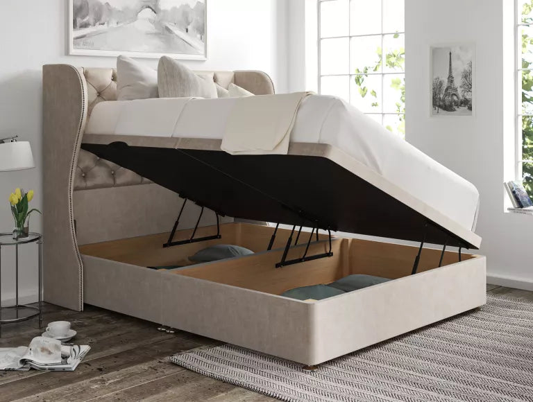 Ottoman bed base lifted open on its gas struts, showing the storage well underneath